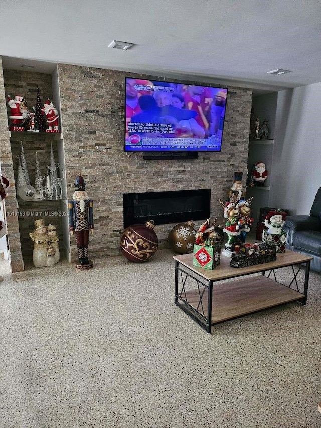 living room with a textured ceiling and a fireplace