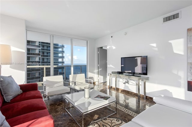 tiled living room with a water view and floor to ceiling windows