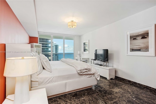 bedroom with tile flooring, access to exterior, floor to ceiling windows, and a water view