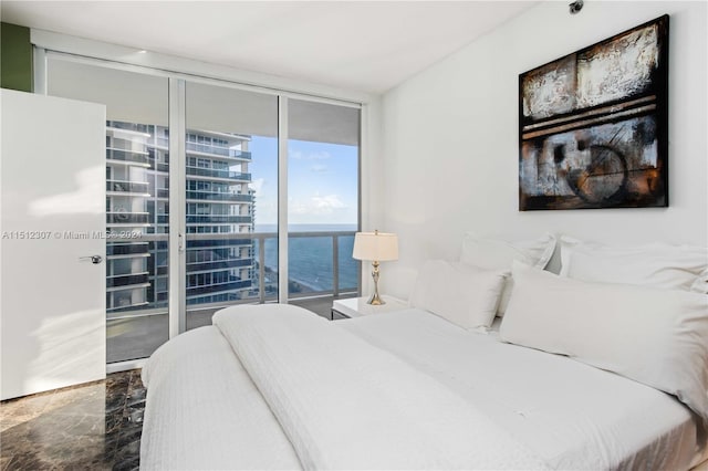 bedroom with expansive windows, tile flooring, and a water view