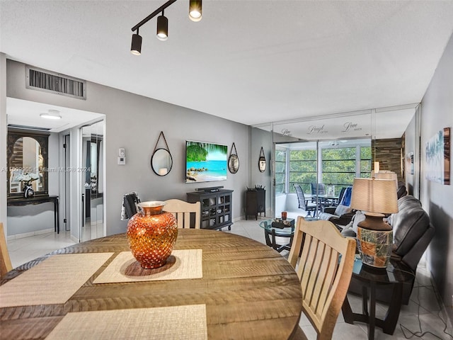 tiled dining space with a textured ceiling