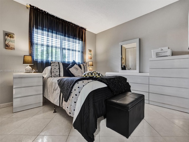 bedroom featuring a textured ceiling and light tile patterned floors