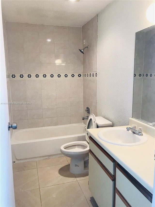 full bathroom featuring toilet, tile flooring, tiled shower / bath combo, and oversized vanity