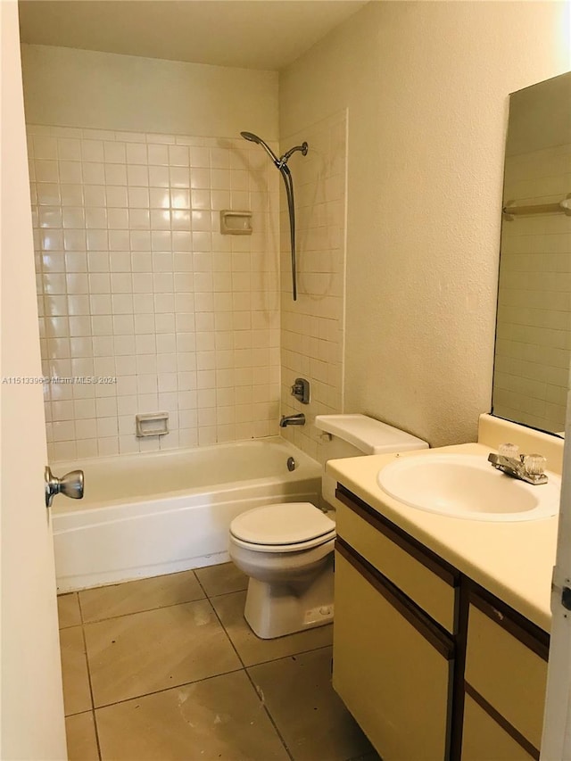 full bathroom featuring tiled shower / bath, toilet, tile floors, and vanity