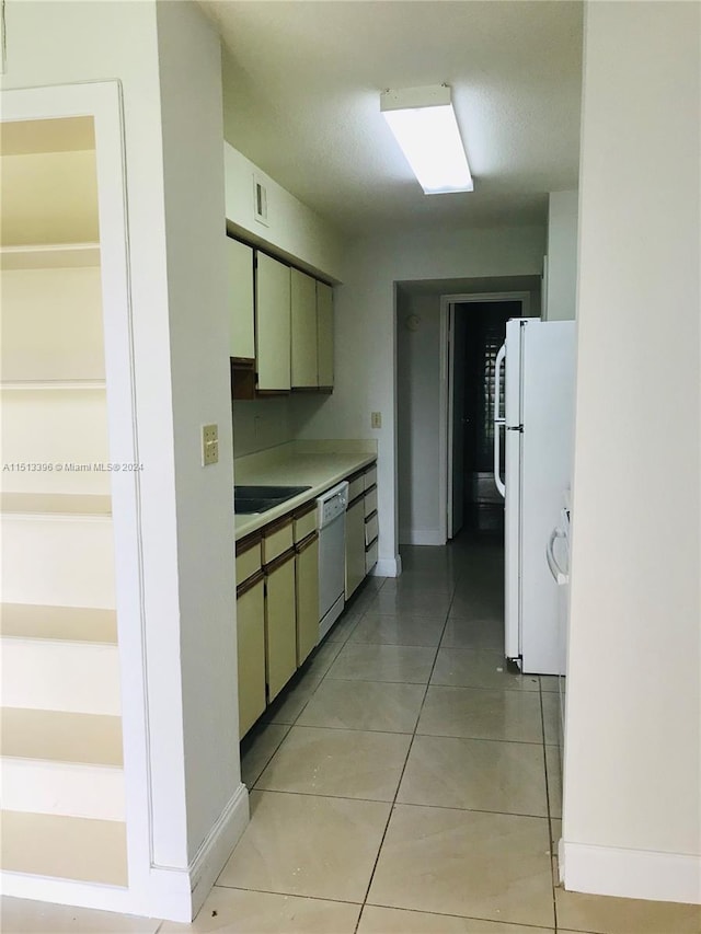 kitchen featuring light tile floors and white appliances