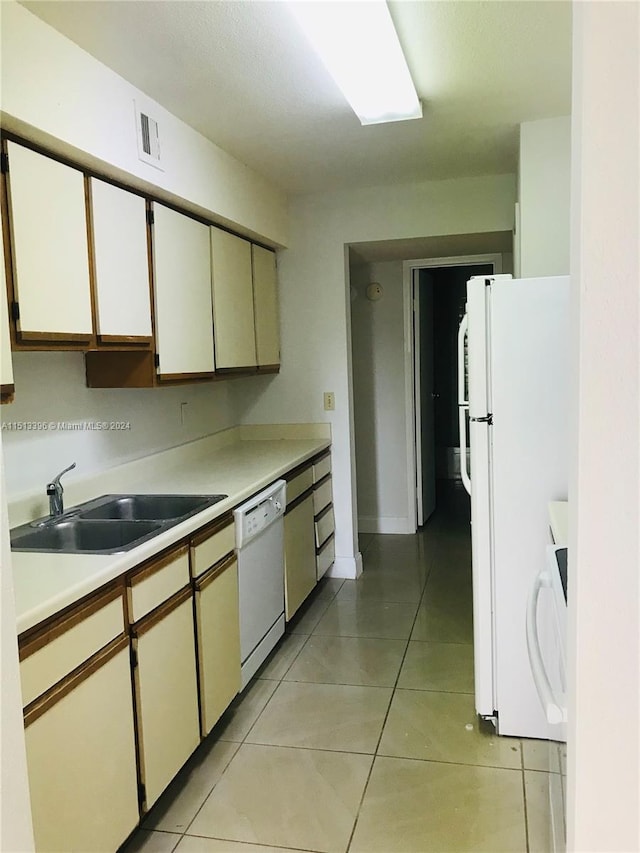 kitchen with white appliances, white cabinets, sink, and light tile flooring