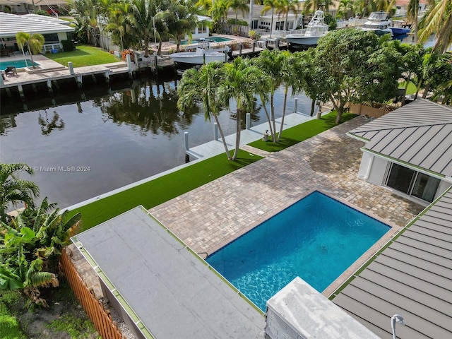 view of pool featuring a patio area and a water view