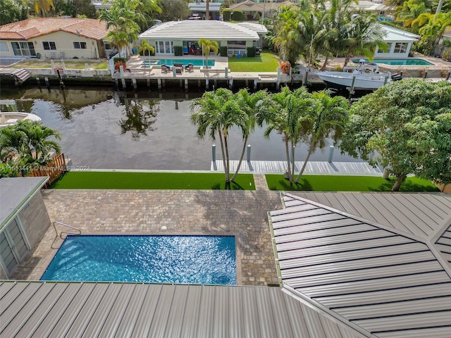 view of swimming pool with a patio area and a water view