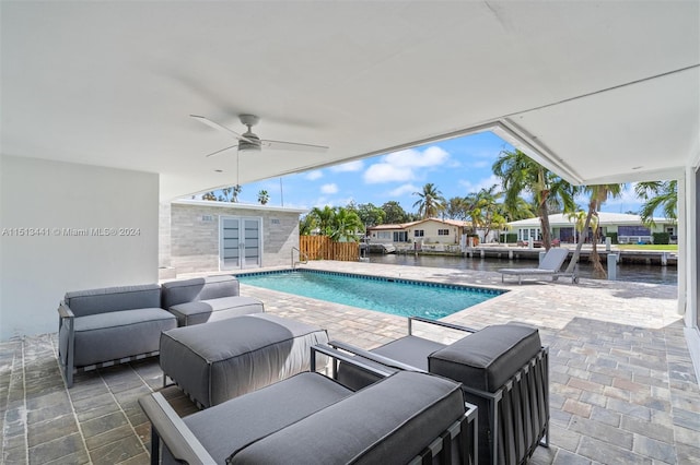 view of pool with a patio, an outdoor hangout area, a water view, and ceiling fan