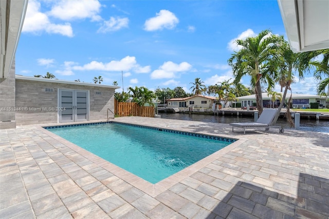 view of swimming pool with a patio and a water view