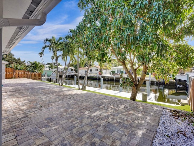 exterior space featuring a patio, a water view, and a boat dock