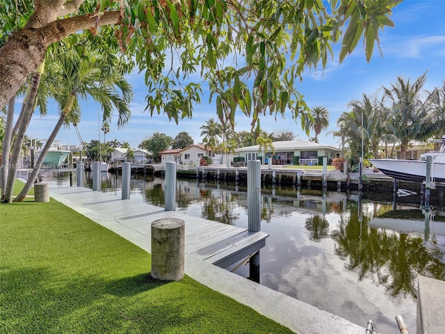 view of dock featuring a lawn and a water view