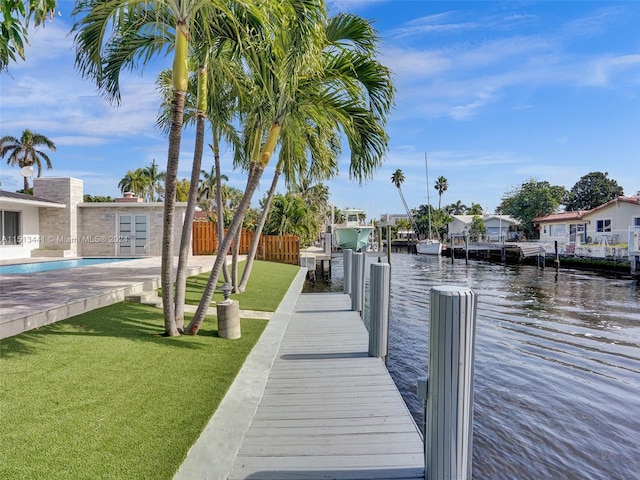 view of dock with a yard and a water view