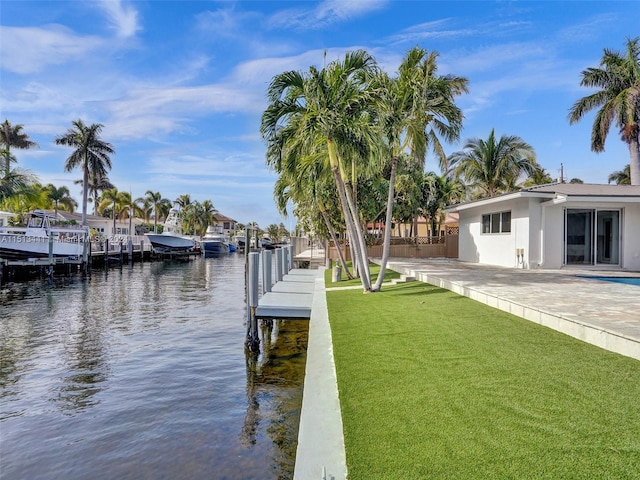 dock area with a patio, a yard, and a water view