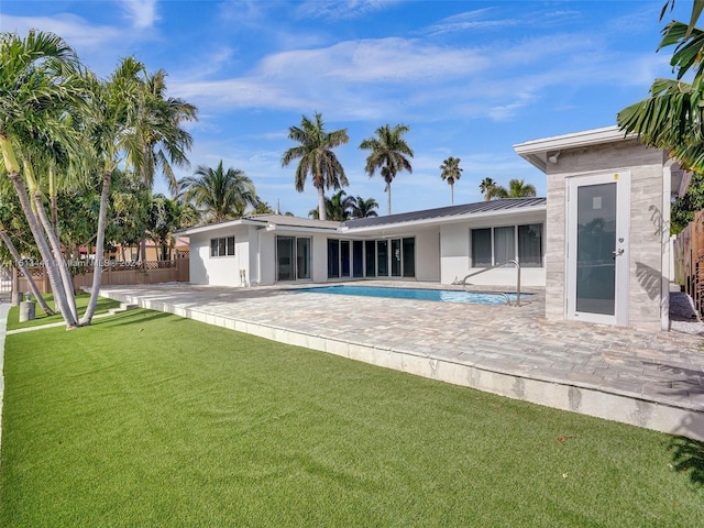 back of property with a yard and a patio area