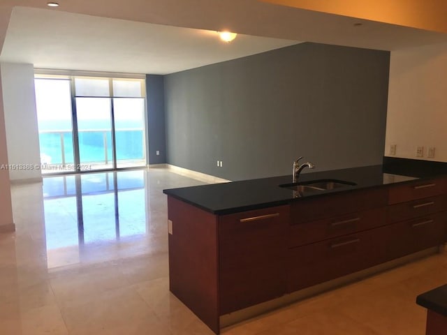 kitchen featuring expansive windows, light tile floors, and sink