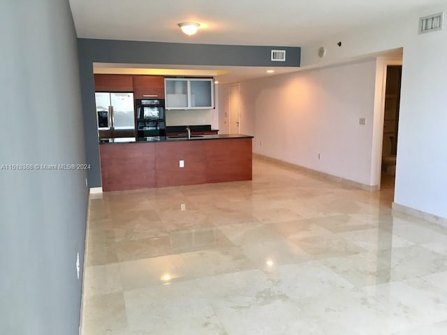 kitchen with stainless steel fridge, light tile floors, and black double oven