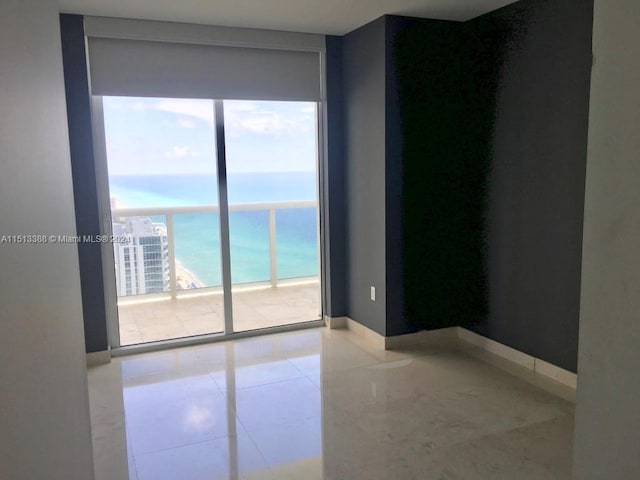 unfurnished room featuring light tile floors and a wall of windows