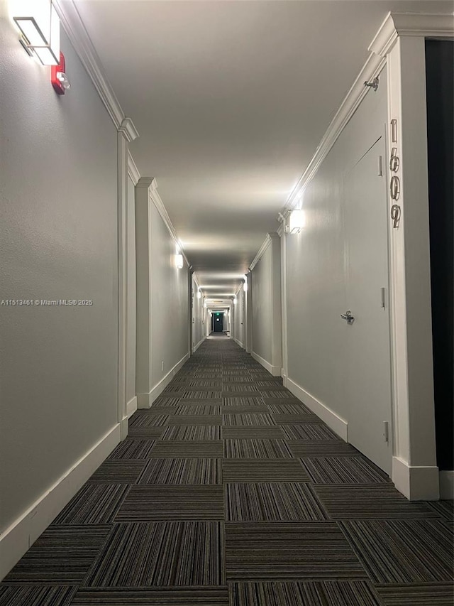 hall featuring dark carpet and crown molding