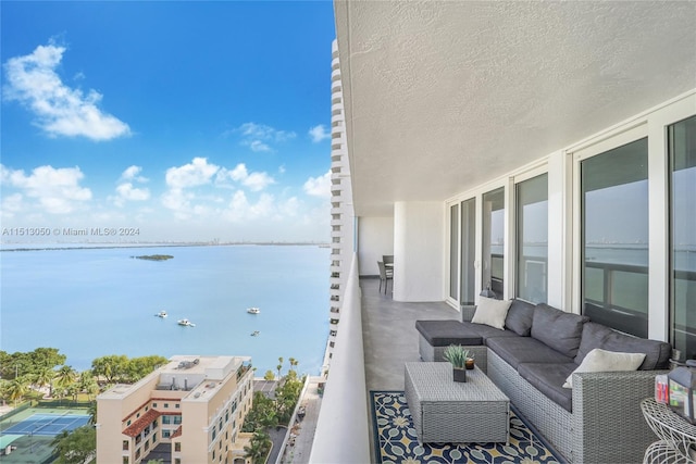 balcony featuring outdoor lounge area and a water view