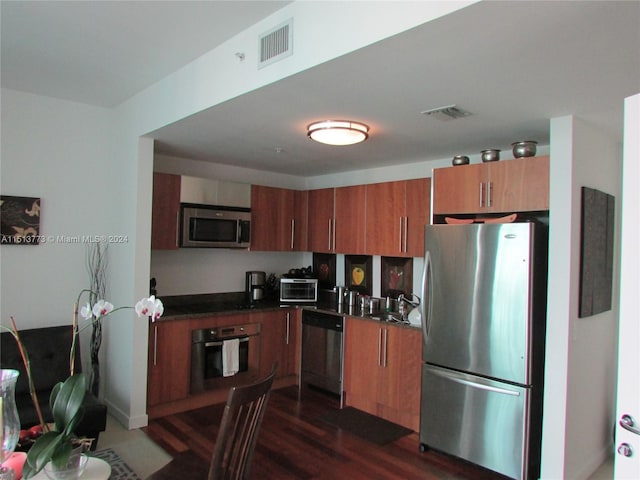 kitchen featuring dark wood-type flooring, appliances with stainless steel finishes, and sink