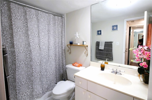 bathroom with curtained shower, vanity, and toilet