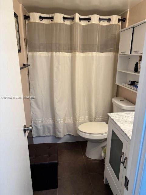 bathroom featuring vanity, tile patterned floors, and toilet