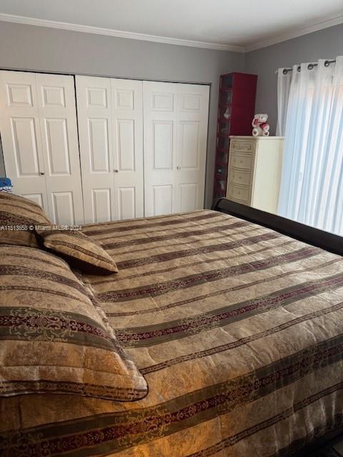 bedroom with a closet and crown molding