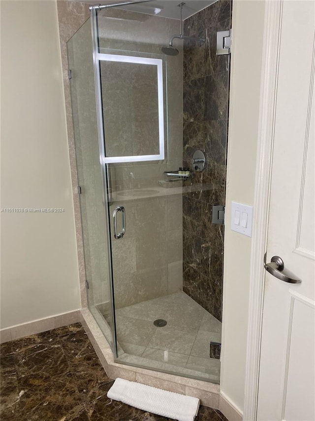 bathroom with a shower with door and tile flooring