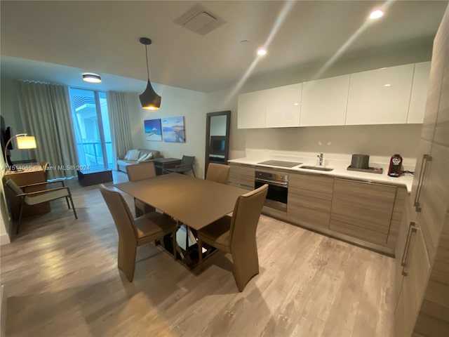 dining area with light hardwood / wood-style flooring and sink