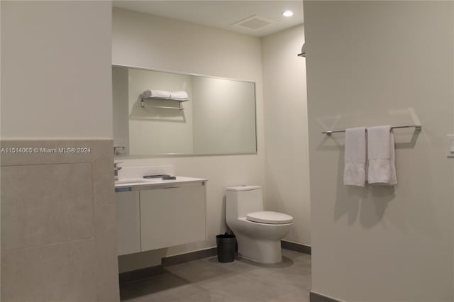 bathroom featuring toilet, tile flooring, and vanity