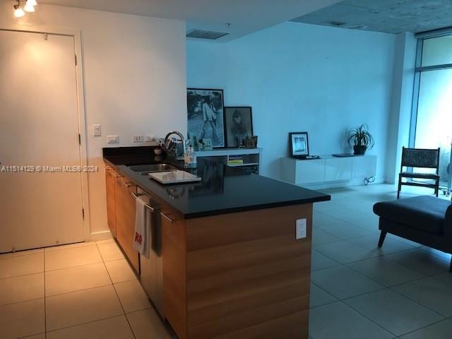 kitchen with sink, light tile patterned flooring, and kitchen peninsula