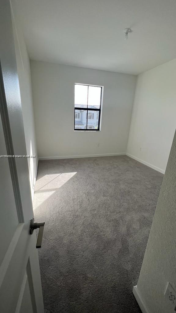 spare room featuring light carpet