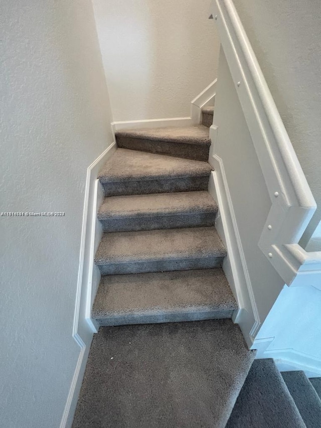 stairs featuring carpet flooring