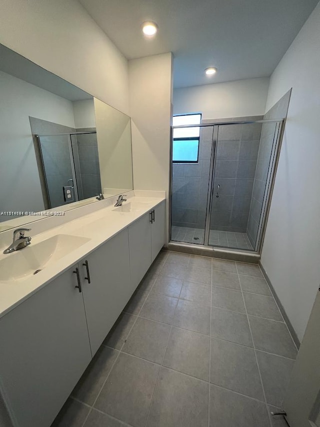 bathroom featuring double sink, tile flooring, a shower with shower door, and large vanity