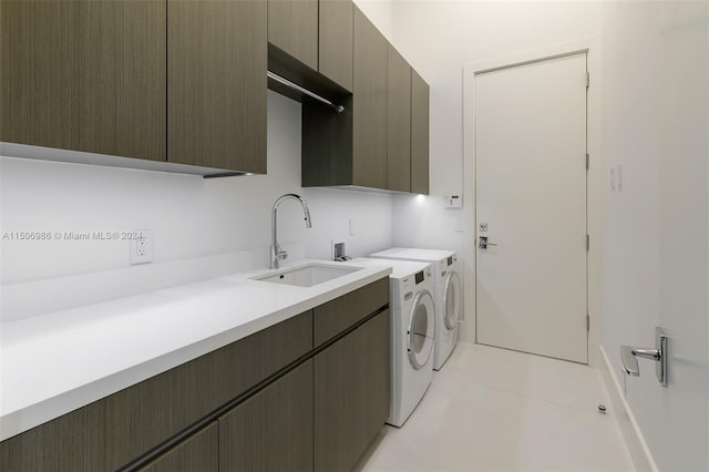 washroom with cabinets, sink, light tile patterned floors, and washing machine and clothes dryer