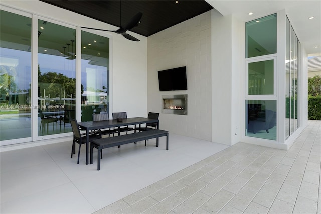 view of patio / terrace featuring exterior fireplace and ceiling fan