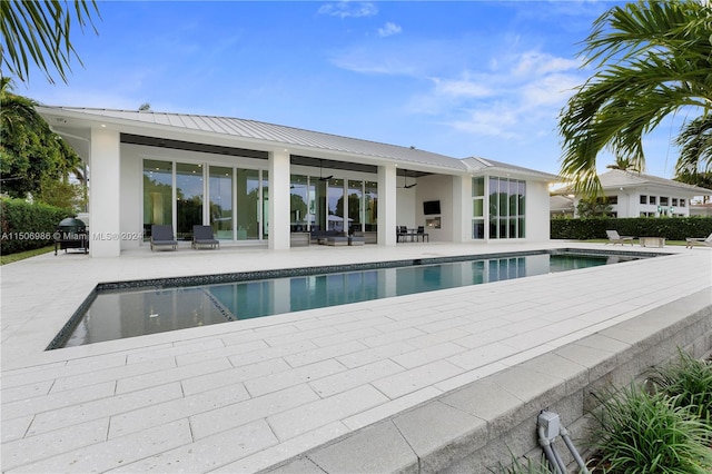 view of pool featuring ceiling fan, a grill, and a patio