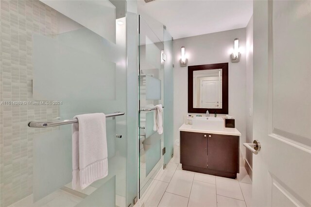 bathroom with vanity, an enclosed shower, and tile patterned floors