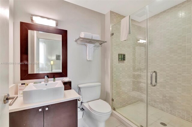 bathroom with vanity, toilet, walk in shower, and tile patterned flooring