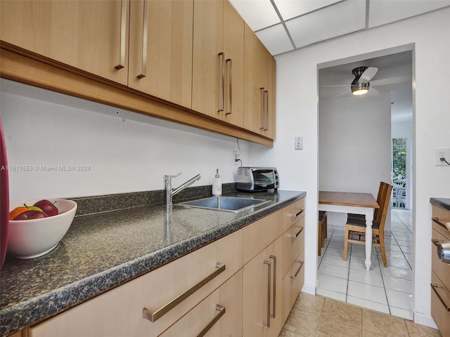 kitchen with light tile patterned floors, light brown cabinetry, and sink