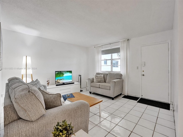 tiled living room featuring a textured ceiling