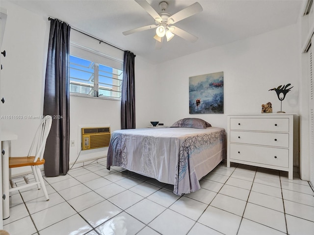 tiled bedroom with a wall unit AC and ceiling fan