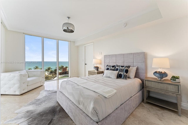 bedroom with expansive windows, a water view, and access to exterior