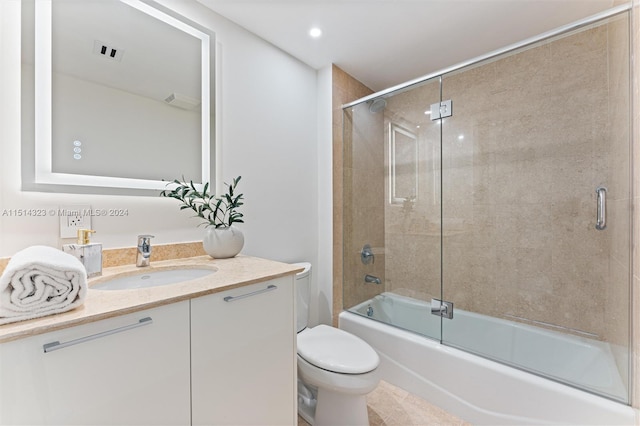 full bathroom with toilet, tile patterned floors, vanity, and bath / shower combo with glass door