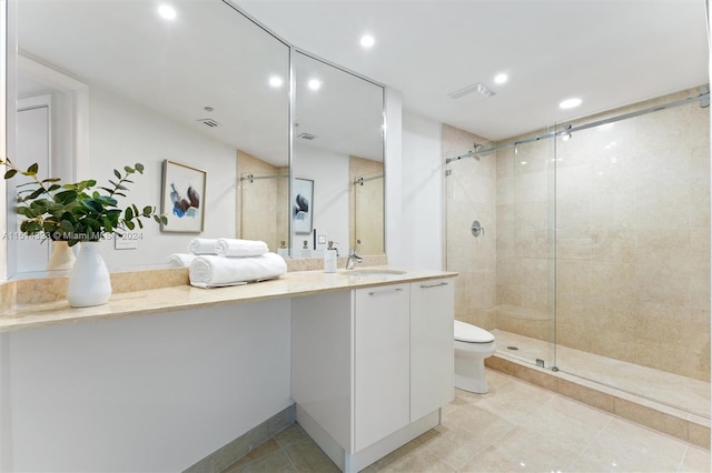 bathroom featuring toilet, tile patterned floors, vanity, and an enclosed shower