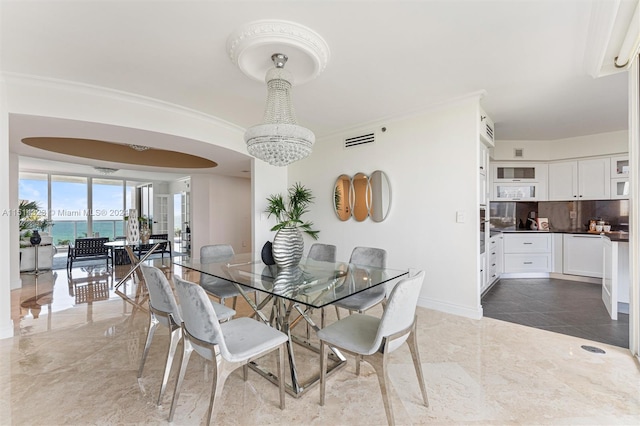 dining room with a chandelier, a water view, and tile patterned flooring