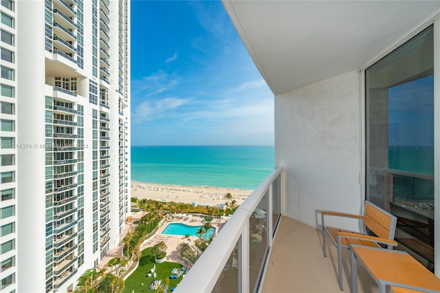 balcony featuring a view of the beach and a water view