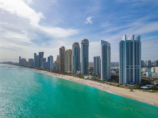 property's view of city featuring a water view and a beach view