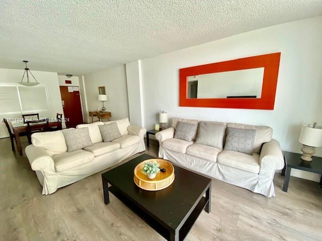 living room with a textured ceiling and wood-type flooring